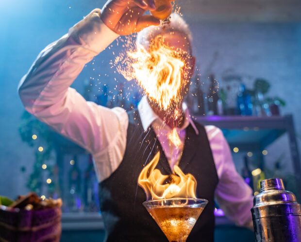 Bartender making a fire flame cocktail in a elegant night club party unique experience. . High quality photo