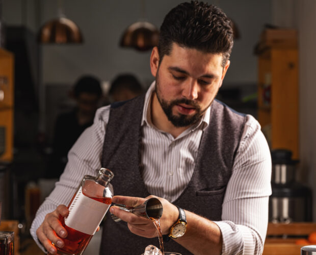 Skilled bartender carefully prepares a refreshing craft cocktail, adding a sophisticated touch to the drink